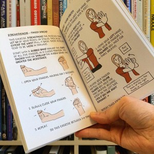 In 'Draw Stronger' author/illustrator Kriota Willberg provides sequential diagrams for self-care. In this image, we see a finger strengthening exercise involving a rubber band. 