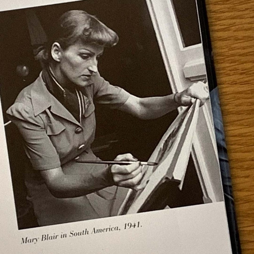 A black and white photo of Mary Blair working on a watercolor painting in South America in 1941. The photo is featured in 'The Art And Flair Of Mary Blair' by John Canemaker.