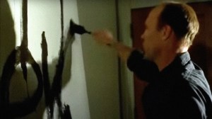 A screen shot of the movie Pollock, showing Ed Harris as Jackson Pollock painting his Mural on a huge, wall-sized canvas.